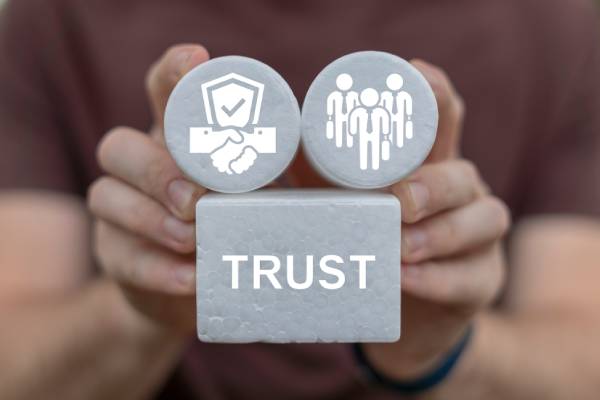 Man holding white blocks sees word TRUST. Trust and Partnership Business Finance Web Technology